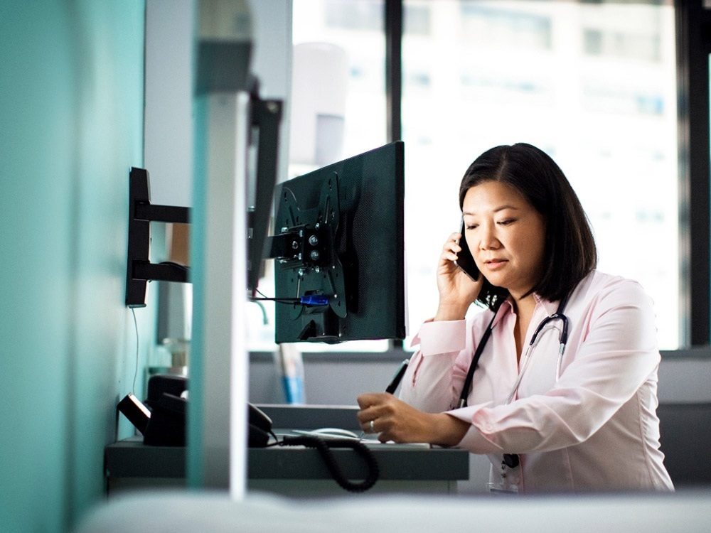 a doctor in a hospital room talking on the phone